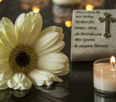 gerbera daisy, candle and verse at a urn or casket service