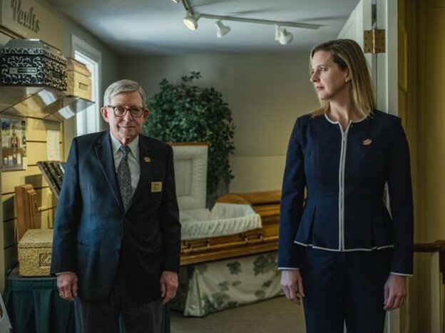 Jim Reid and Sarah Reid of James Reid Funeral Home standing in the funeral home's casket, urn, and keepsake jewelry Selection Room