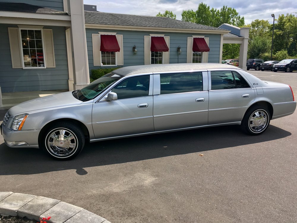 stretch limousine, silver with leather interior, carries seven people in procession