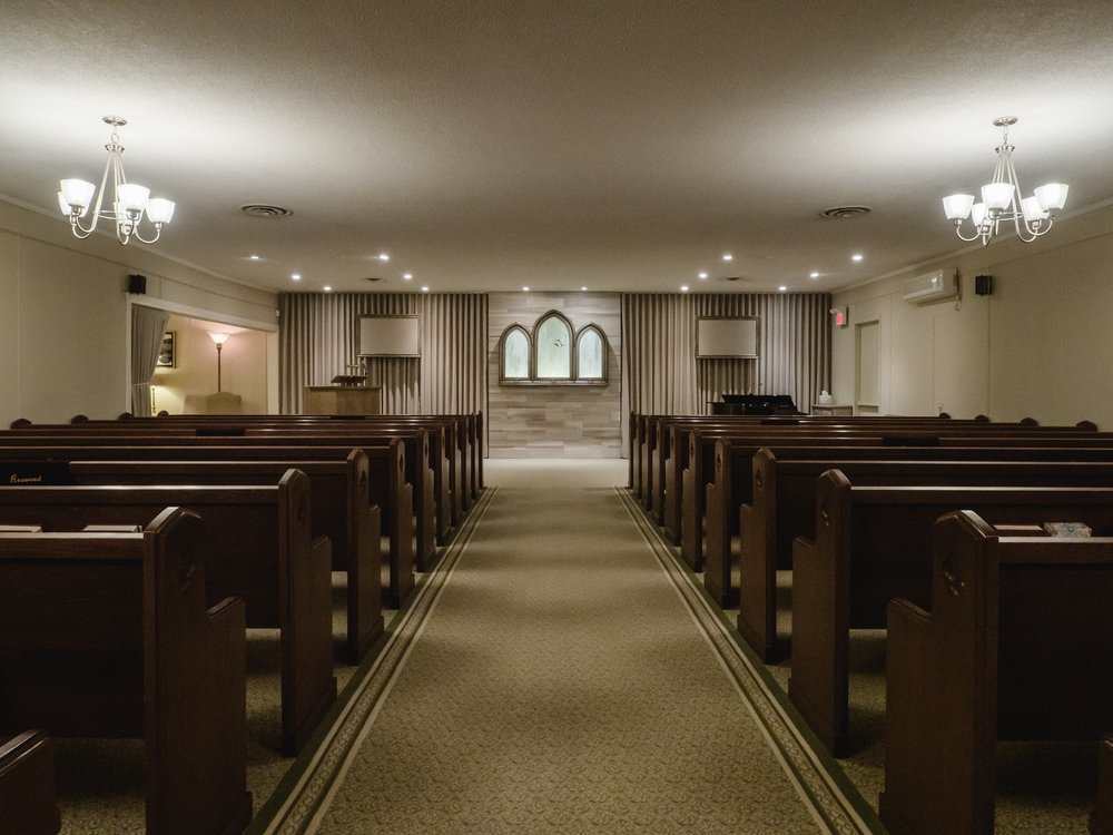 The James Reid Funeral Chapel has cherry wood pews, a brick centrepiece, and contemporary lighting