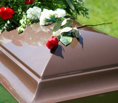 flowers on a casket at a graveside service